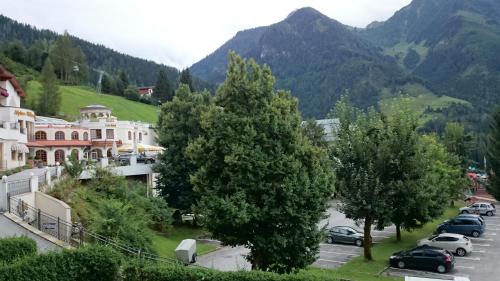 a town in the mountains with cars parked in a parking lot at Apartment im Alpendorf in Sankt Johann im Pongau