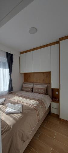 a bedroom with a large bed with white cabinets at Apartman Mali princ Jahorina in Jahorina