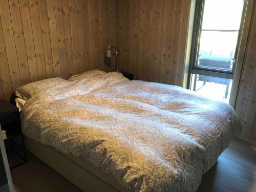 um quarto com uma cama com um cobertor em Ny og moderne hytte i Stryn. Solrik plassering em Stryn