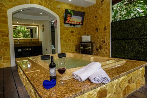 una vasca da bagno con una bottiglia di vino e un bicchiere di Palo Alto Glamping Hotel a Quesada