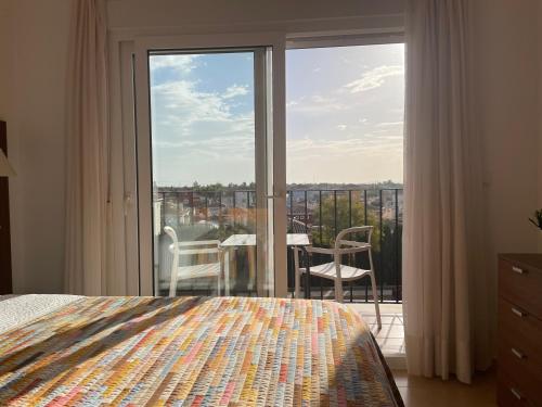 1 dormitorio con cama y vistas a un balcón en Lakeview Residence 'Casa Naranjas' Mar Menor Golf and Leisure Resort en Torre-Pacheco