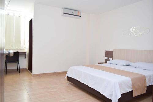 1 dormitorio con 1 cama grande y escritorio en Hotel Sterling en Cúcuta