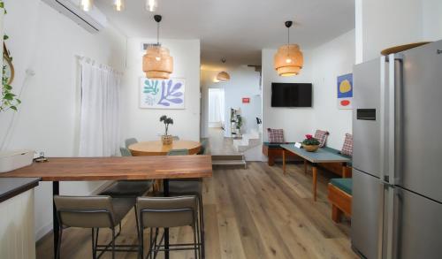a kitchen and dining room with a table and a refrigerator at Rosen Villa at Ramat Hahayal in Tel Aviv