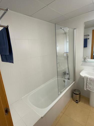 a white bathroom with a shower and a sink at Lakeview Residence 'Casa Naranjas' Mar Menor Golf and Leisure Resort in Torre-Pacheco