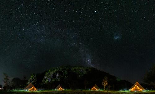 a starry night with the milky way over a mountain at Amanecer Glamping in llifen