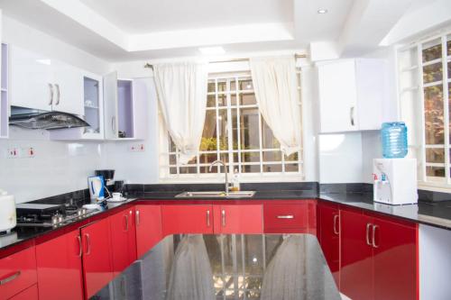una cocina con armarios rojos y una ventana en 4bedroom Navilla westlands Nairobi, en Nairobi