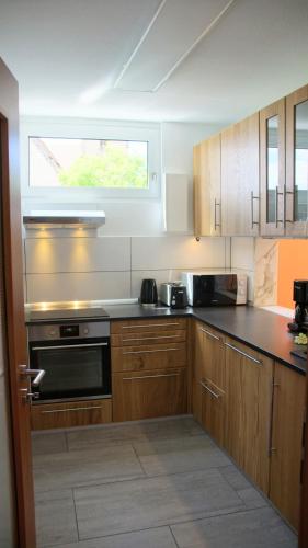 a kitchen with wooden cabinets and a window at 80 qm Apartment Alessia Nürnberg in Nuremberg