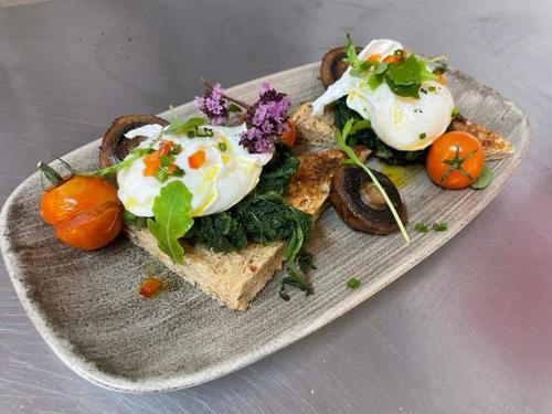 a plate of food with eggs and vegetables on it at Borgie Lodge Hotel in Borgie