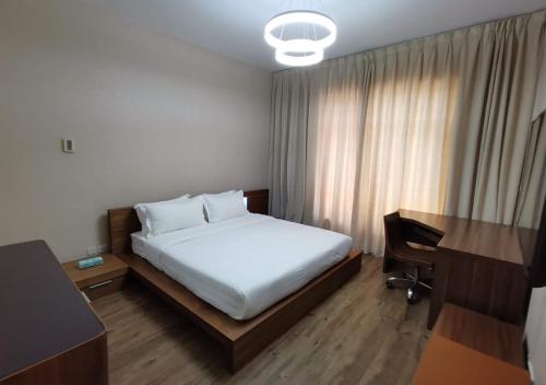 a hotel room with a bed and a desk and a desk at Adar Homes 2 - شقة غرفتين نوم مطلة على البحر in King Abdullah Economic City