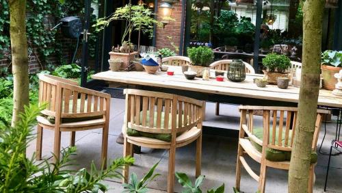 einen Tisch mit Stühlen und Topfpflanzen darauf in der Unterkunft Verrassende ruime Stadswoning nabij station, centrum met unieke tuin. in Venlo