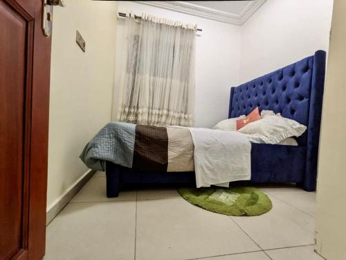 a bedroom with a blue bed and a rug at Appartement meublé haut standing 1CH en RDC in Yaoundé