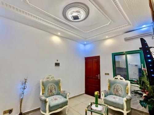 twee stoelen in een woonkamer met een plafond bij Appartement meublé haut standing 1CH en RDC in Yaoundé