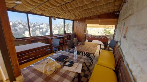 Carob Hostel في عمّان: غرفة مع طاولة وكراسي في مبنى