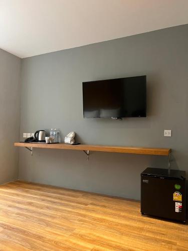 a room with a flat screen tv on a wall at Woodstory Boutique Hotel in Bangkok