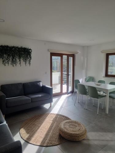 a living room with a couch and a table at Hortelã da Ribeira - Serra da Estrela in Cortes do Meio