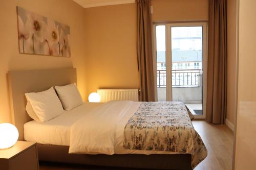 une chambre avec un lit et un balcon dans l'établissement Platinia home, à Cluj-Napoca