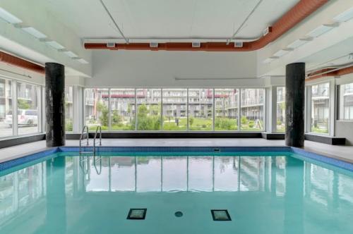 a swimming pool with blue water in a building at The Best Spot in Ottawa