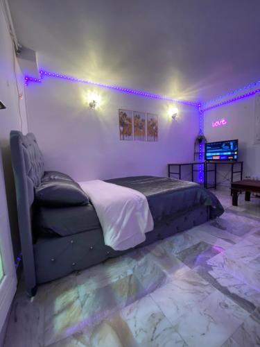 a bedroom with a bed in a room with purple lights at Nice Studio Livry in Livry-Gargan