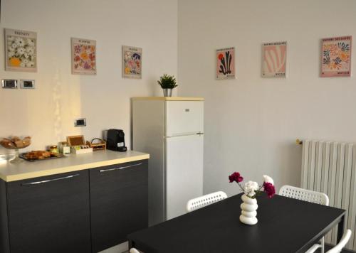 a kitchen with a black table and a refrigerator at la Dolce Vita - Appartamento con parcheggio privato vicino al centro e all'ospedale in Asti