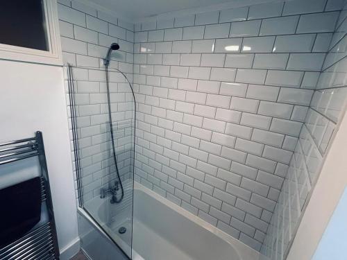 a white tiled bathroom with a shower at Brighton Beach House in Brighton & Hove