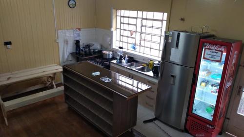 uma pequena cozinha com um frigorífico e um lavatório em Casarão 2 em Caxias do Sul