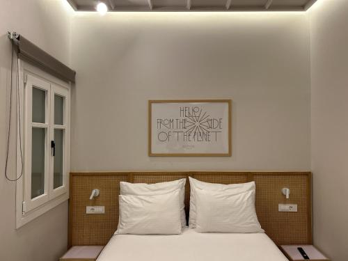 a bedroom with a bed with white sheets and a window at Belle Athenes - Luxury Rooms at Monastiraki Railway Station in Athens
