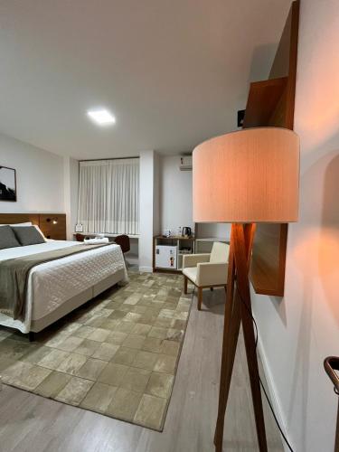 a bedroom with a bed and a lamp at Zallon Hotel Executivo in Lajeado