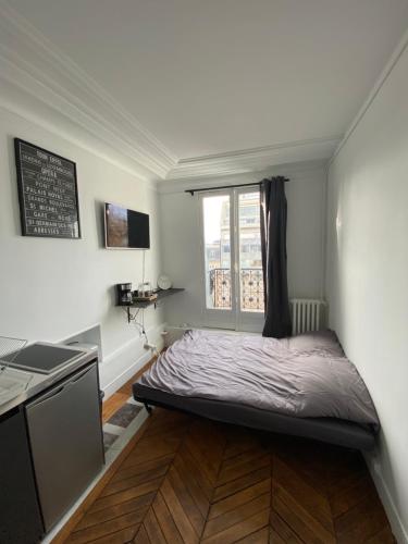 une petite chambre avec un lit et une fenêtre dans l'établissement The room of the Eiffel Tower, à Paris