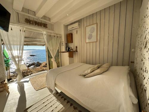 une chambre avec un lit et une vue sur l'océan dans l'établissement lou cabanou, à Sainte-Maxime