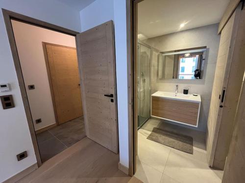 uma casa de banho com um lavatório e um espelho em La Terrasse de l Alpe d Huez em Alpe-dʼHuez