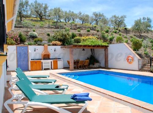 una piscina con tumbonas junto a una casa en Casa Nobleza en Málaga