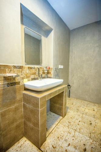 a bathroom with a sink and a mirror at Villa RISITHENMI in Ahangama