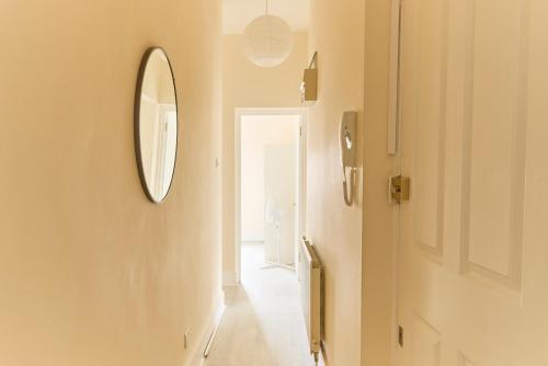 a hallway with a mirror on the wall and a door at Central London Flat, Stylish 1BR near Shoreditch in London