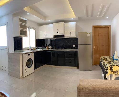 Il comprend une cuisine équipée d'un réfrigérateur et d'un lave-linge/sèche-linge. dans l'établissement Dar sammoud S+1, à Kelibia
