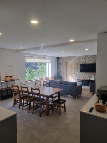 a living room with a table and chairs and a couch at Hortelã da Ribeira - Serra da Estrela in Cortes do Meio