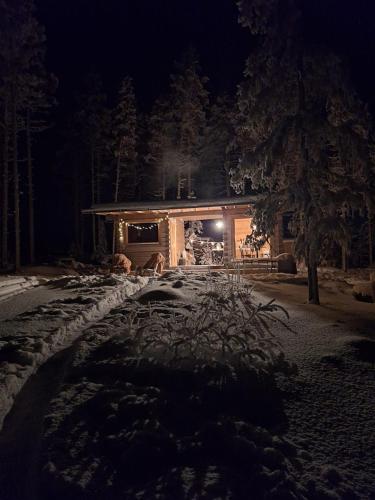 a house at night with snow on the ground at Wilderness Cabin Onnela in Rovaniemi