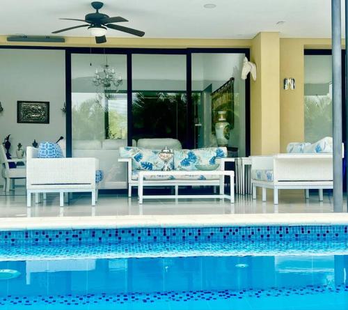 een huis met een zwembad met stoelen en een bank bij Luxury Mocawa House: Two Jacuzzis, Pool & BBQ. in La Tebaida