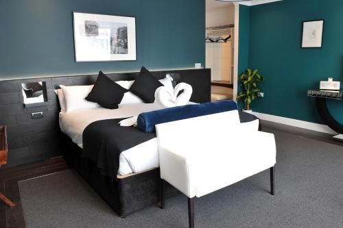 a bedroom with a bed with black and white pillows at The Kings Arms Hotel in Berwick-Upon-Tweed