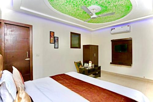 a bedroom with a bed and a ceiling with a window at Hotel Premium Blossom Rooms in Agra
