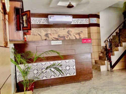 a lobby with stairs and a wall with a mural at Hotel Premium Blossom Rooms in Agra