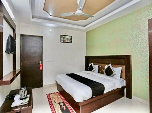 a bedroom with a large bed with a ceiling at Hotel Premium Blossom Rooms in Agra