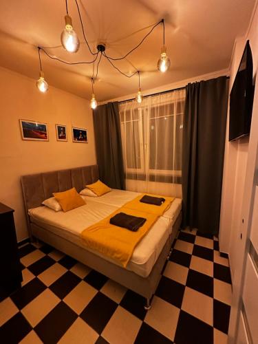 a bedroom with a bed and a checkered floor at Apartament 70’s in Kołobrzeg