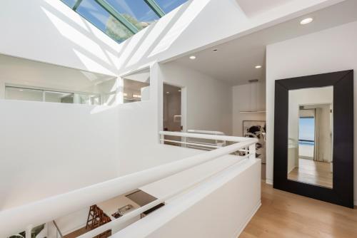 a white staircase in a house with a skylight at Malibu Breeze - hot tub, ocean view, steps to beach in Malibu