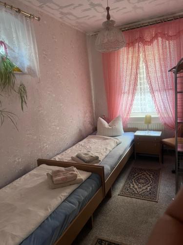 two beds in a room with a window at Mehrbettzimmer Erdgeschoss in Münchenbernsdorf