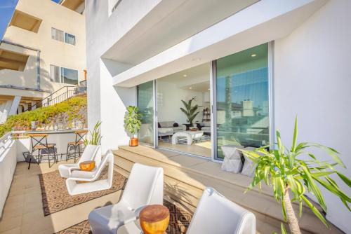 an outdoor patio with white chairs and tables at Malibu Breeze - hot tub, ocean view, steps to beach in Malibu