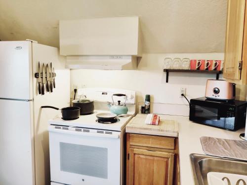 eine Küche mit einem weißen Herd und einem weißen Kühlschrank in der Unterkunft Soleil Salem in Salem
