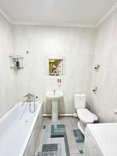 a bathroom with a toilet and a sink and a tub at ЖК Отау in Almaty