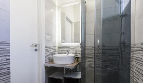 シラクーサにあるArtemide House - Monolocale Ortigia Wifiの洗面台とガラスのシャワーを備えたバスルーム