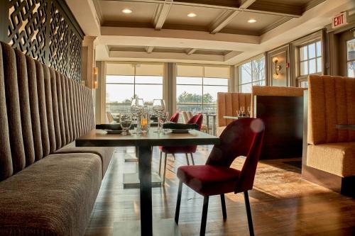 a dining room with a table and red chairs at Rawley Resort, Spa & Marina in Port Severn
