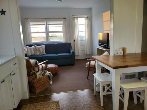 uma sala de estar com um sofá azul e uma mesa em Barrington Inn Barn em New Shoreham